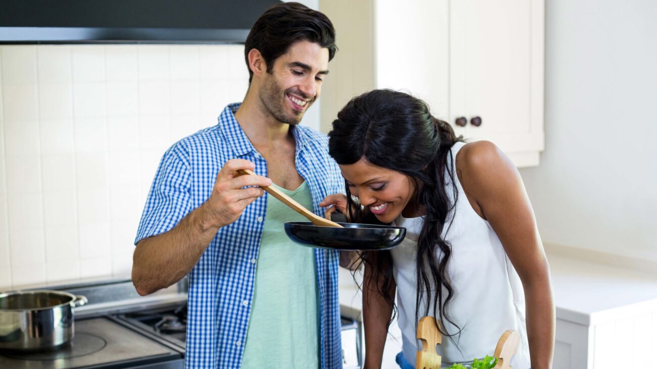 Young couple cooking food together in kitchen